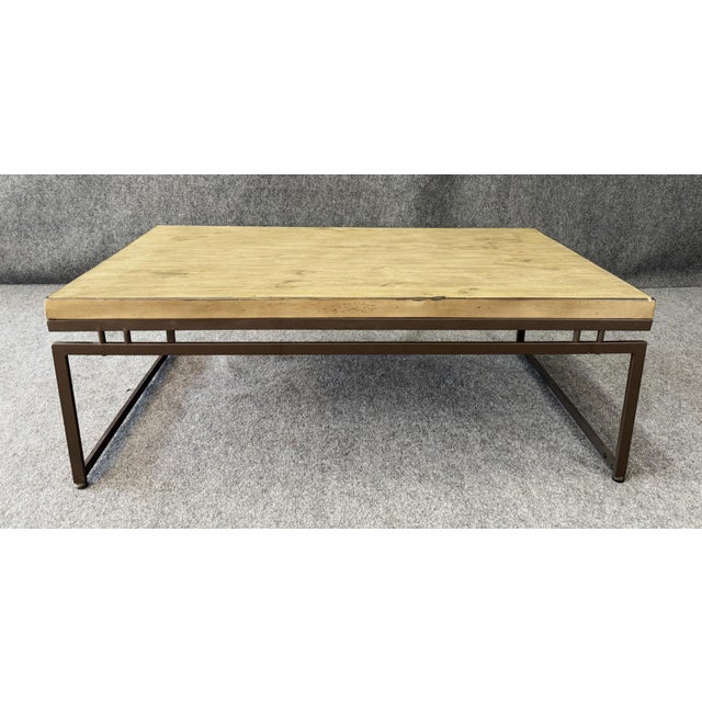 This modern coffee table features a sleek gray wood top paired with a clean-lined iron base, creating a balanced...