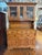 Traditional wooden china hutch featuring glass-paneled upper cabinets, decorative brass-tone hardware, and generous drawer...