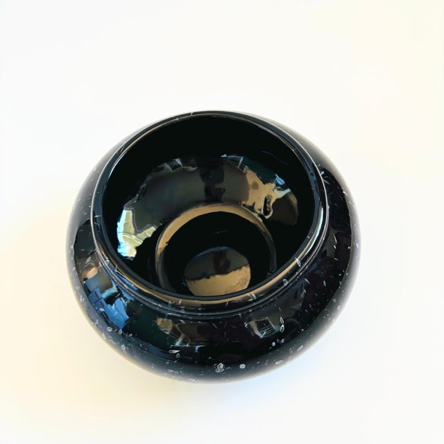 A mid century ceramic vessel to use as a planter bowl or vase. Glossy black glaze with a speckled white pattern. Measures...