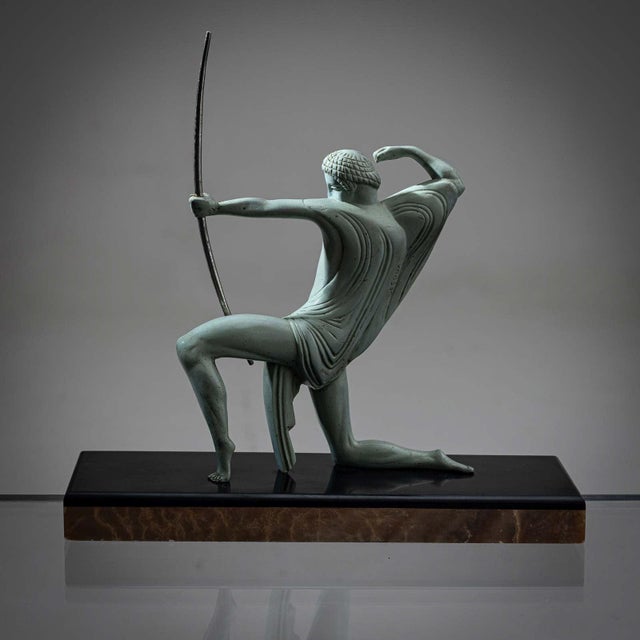 Green patinated bronze sculpture of an archer by Michel Decoux (1837-1924). This petite Art Deco sculpture beautifully...