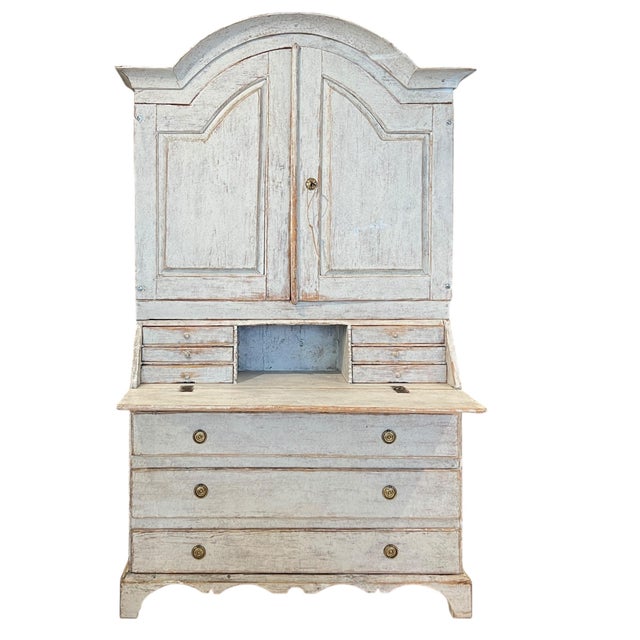 A stately Gustavian tall case secretary featuring a refined, neoclassical silhouette with paneled doors, drop down writing...