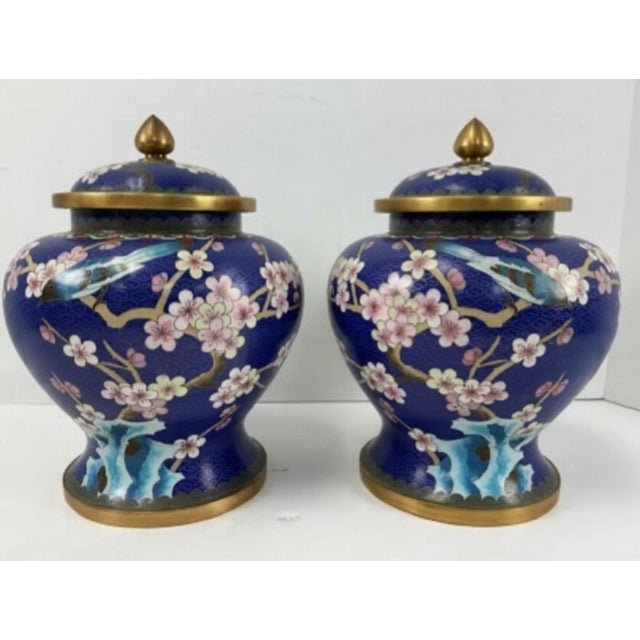 A striking pair of vintage Chinese cloisonné ginger jars featuring richly colored enamel decoration against a deep cobalt-...
