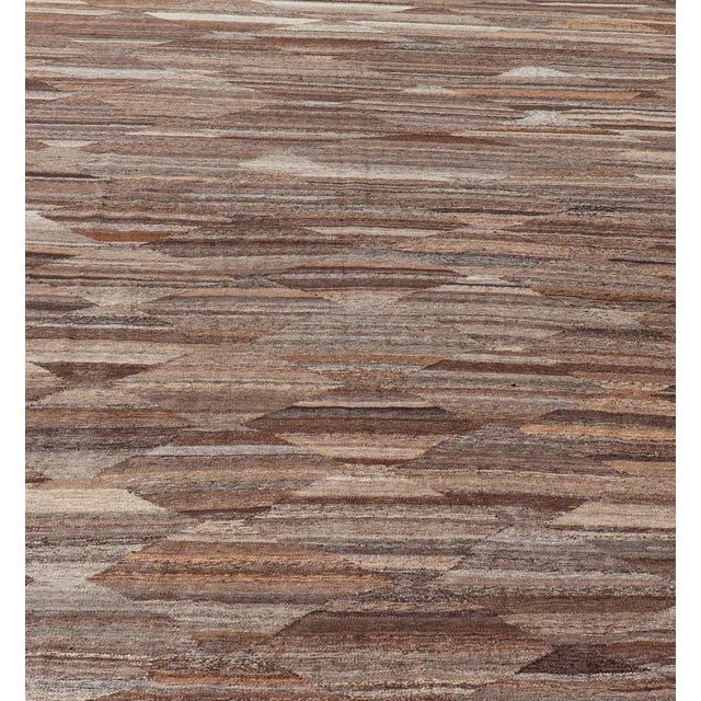 Measures: 8'8 x 11'9. This flat-weave tribal kilim has been hand-woven. The rug features an all-over solid/diamond design,...