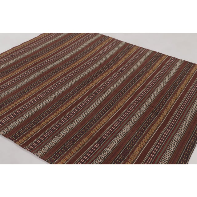 Made with handwoven wool circa 1950-1960, this 6x7 vintage flat-weave Kilim is a particularly intricate and sought-after...