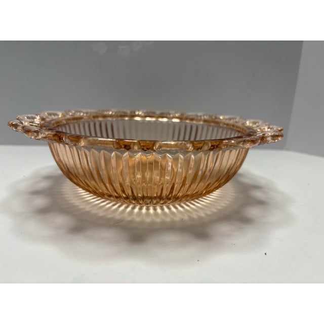 This elegant vintage pressed glass serving bowl features a warm peach-pink hue with beautifully ribbed sides, a classic...