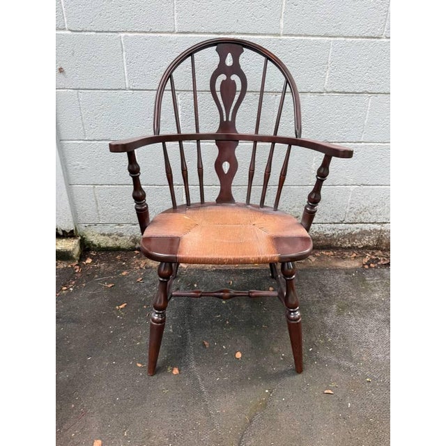 Vintage Windsor-Style Hoop-Back Rush Seat Armchair It features a woven rush seat, a distinctive pierced central splat, and...