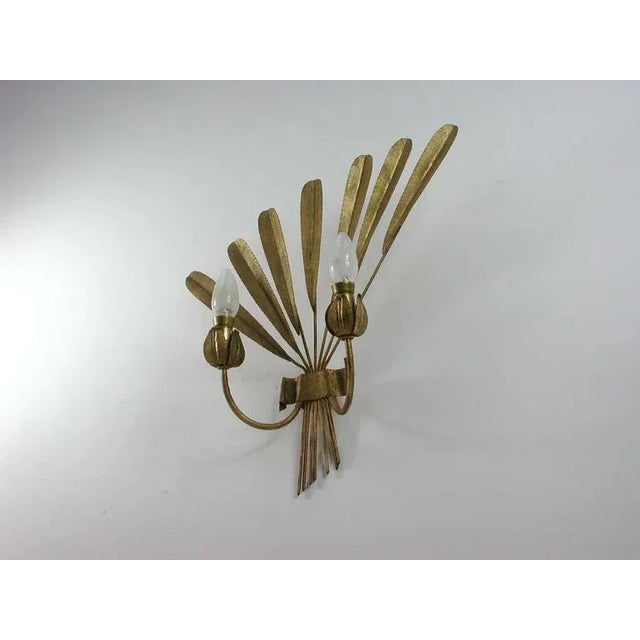 This wall light was manufactured in Spain in the 1950s. It is made of gilt metal and has got two sockets for E14 screw on...