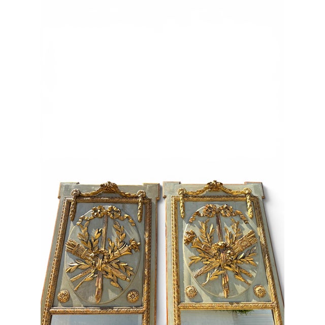An elegant pair of 19th century French painted and giltwood trumeau mirrors. Each mirror features a tall painted...