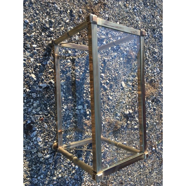 This is a mid century regency style solid brass side table. This side table has a bronze patina to the brass with a glass...