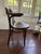 Antique bentwood armchair with curved wood arms and a rounded back. Made in the classic bentwood style, with a dark...