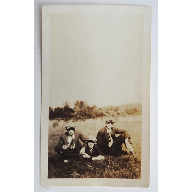 Early 20th century sepia tone snapshot photograph of three men lounging in a field. Unframed, small corner crease, age...