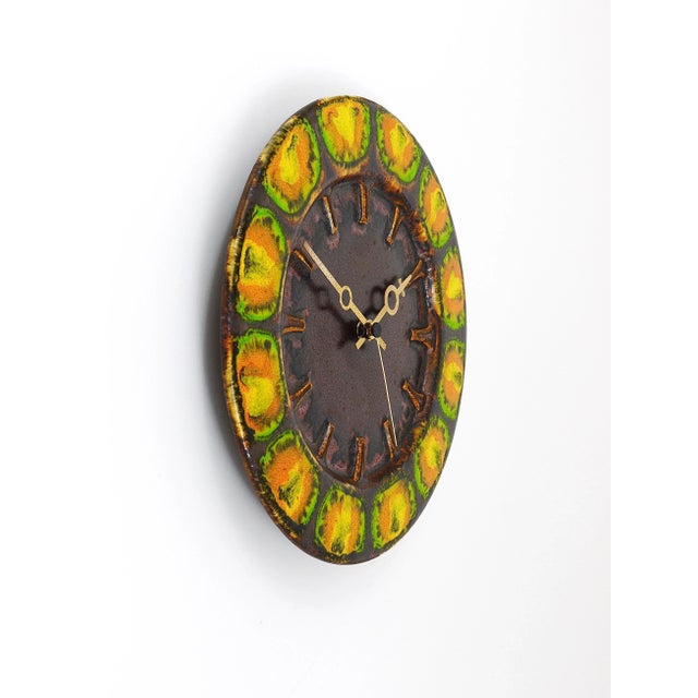 A beautiful round Midcentury Brutalist wall clock, executed by Kienzle Germany in the 1970s. The clock has a housing made...