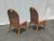 Exceptional vintage boho chic bamboo rattan dining chairs. Each feature a wicker back rest with a baby pink fabric seat...