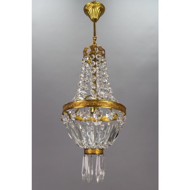French Empire-style brass and crystal glass basket chandelier. Charming and compact French Empire-style crystal glass and...