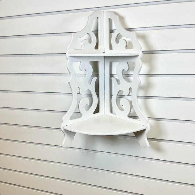 A pretty little white cutout corner shelf. The vintage piece features two shelves for your collectibles or framed...