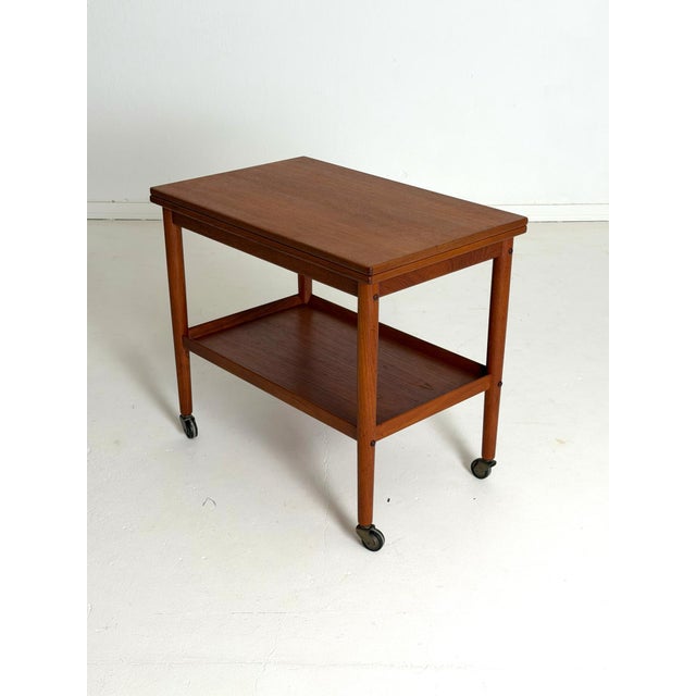 Grete Jalk Teak Flip-Top Serving Trolley by Poul Jeppesens Møbelfabrik An elegant teak serving trolley designed by Grete...
