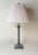 Elegant French neoclassical table lamp featuring a richly detailed silvered metal column base with beautiful aged patina....