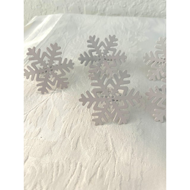 Charming set of eight vintage white metal napkin rings in a snowflake design. Great condition.