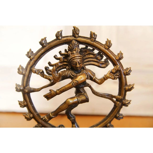 Vintage petite brass Nataraja statue depicting the Hindu god Shiva dancing. Features intricately carved details and aged...