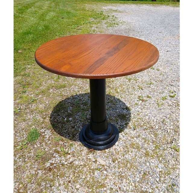 Antique Round Oak Top Pub Table with Cast Iron Column Base An antique pub table with a round solid oak top and a cast iron...