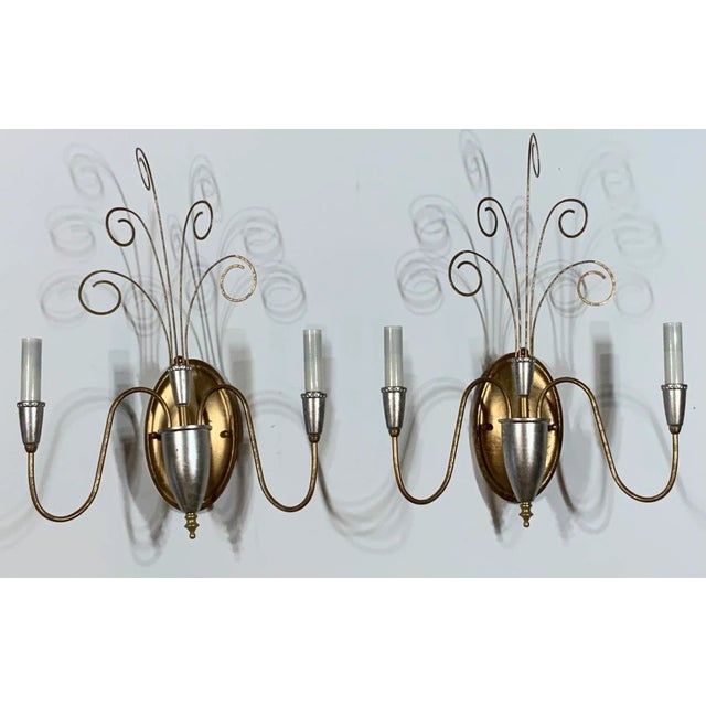 Elegant pair of wall sconces made of metal, painted in silver and gold, with two 60/watt light each sconce. Electrified...