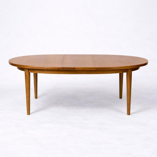 A beautifully proportioned mid-century oval extending dining table by Sutcliffe of Todmorden, showcasing the refined...