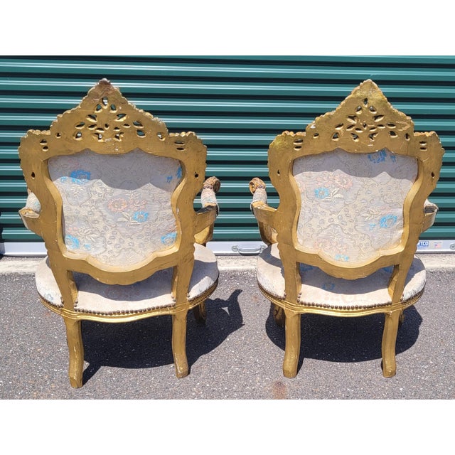 A fine pair of antique French Rococo style burger chairs. Features wood carved frames under plaster sparkly fabric in good...