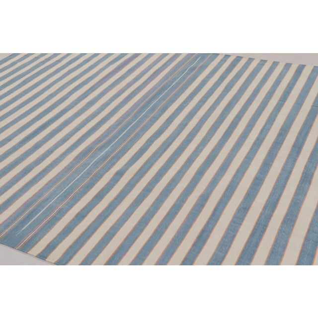 This 8x10 Dhurrie rug features horizontal stripes in ivory and slate blue, and represents an exciting contemporary...