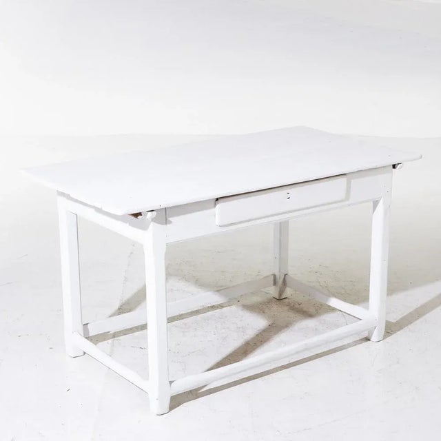 Table in Swedish farm baroque from the 19th century in white version. Cross struts in the foot area there are and a drawer...