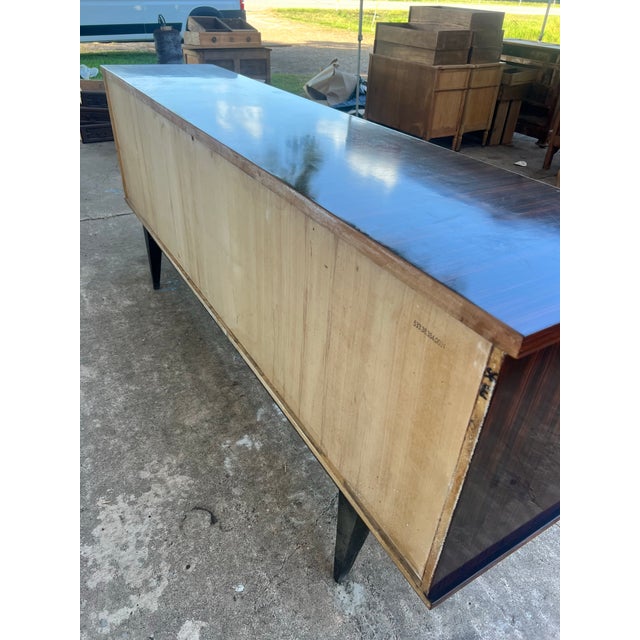 A striking French Art Deco sideboard crafted circa 1940s in luxurious Macassar ebony veneer. Showcasing dramatic geometric...