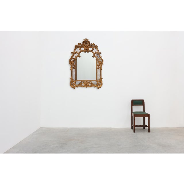 An exuberant Rococo style wall mirror by Deknudt, Belgium, dated 1974. Richly ornamented with scrolling acanthus foliage,...