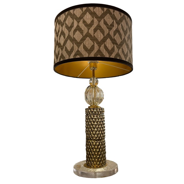 Pair of table lamps with a Murano glass disc base. The body is divided into two parts: a cylindrical section in gold-...