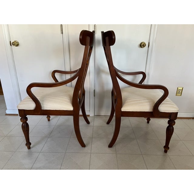 Ethan Allen British Classics collection arm chairs. They feature yoke backs, turned and fluted legs, and carved medallions...