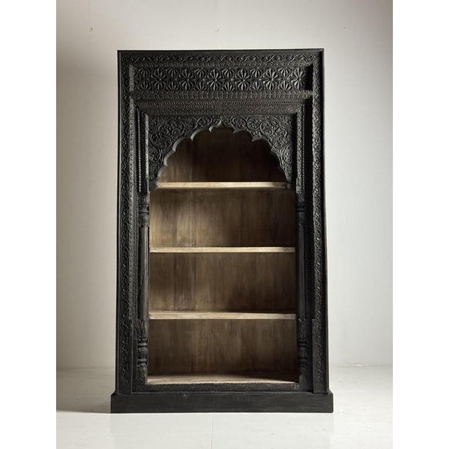 Very large and heavy Indian bookcase. Originally from India, late 20th century. In very good condition. Black exterior and...