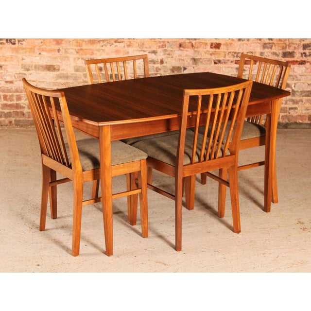 Mid century walnut extending dining table and 4 chairs by vanson, circa 1950s. The extension leaf stored underneath the...