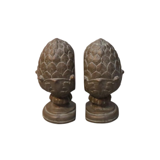 A pair of large pineapple finial shaped bookends. Cast alabaster with a tin glaze, each pineapple has a leafy crown and...