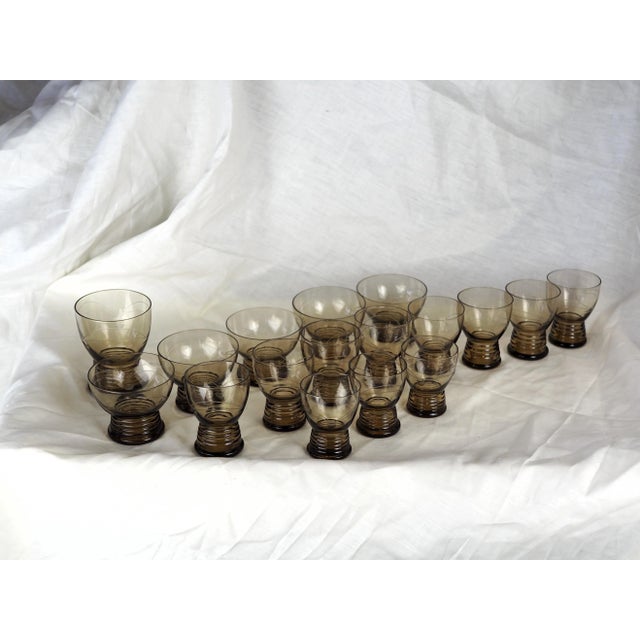 Set of 17 vintage glasses: black smoked glass, engraving with two half-rounds connected by double arcs, round foot with a...