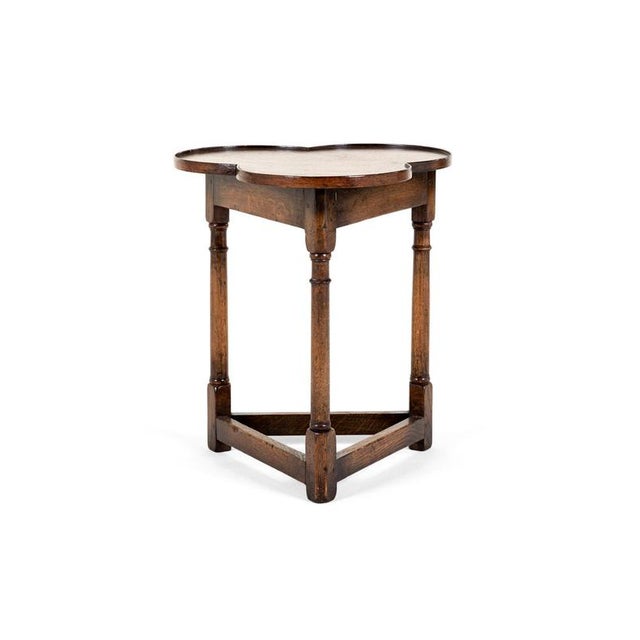 An unusual late victorian english oak occasional table with a trefoil or clover leaf shaped top with a shallow lip to the...