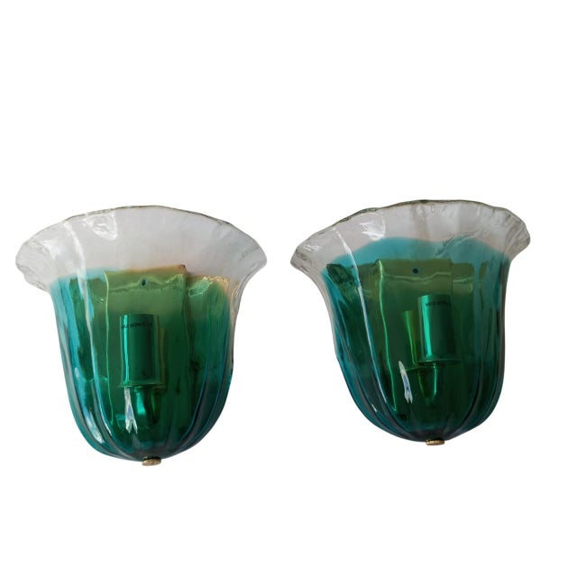 The glass, shaped like a flower, harmoniously combines green and transparent hues, creating a mesmerizing visual effect...