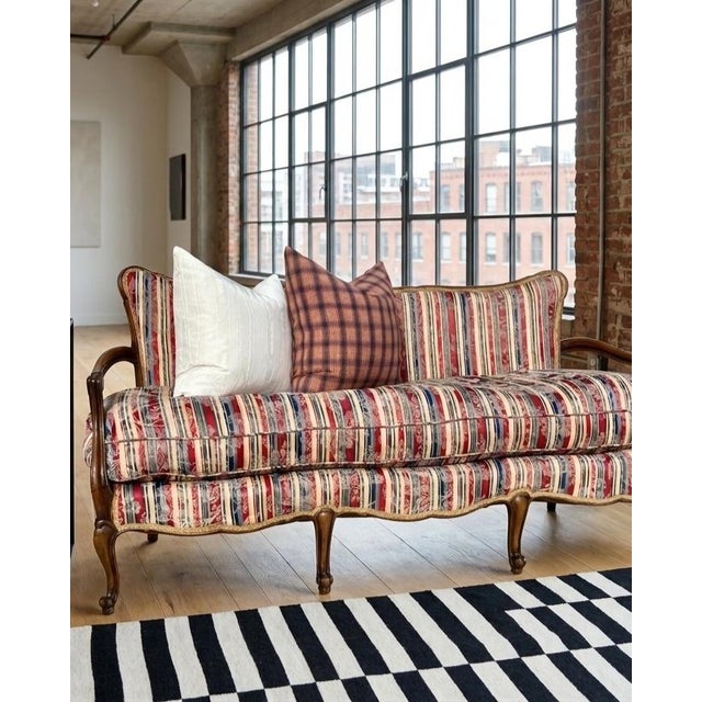 This 71-inch canapé is a sophisticated exploration of the French Provincial form, dating to the mid-century revival....