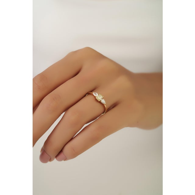 This three-stone engagement ring features 0.67 carats of diamonds, 14K yellow gold. The center diamond accented by two...