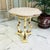 Vintage Hollywood Regency side table featuring a shaped pink marble top over an ornate gilt pedestal base with...