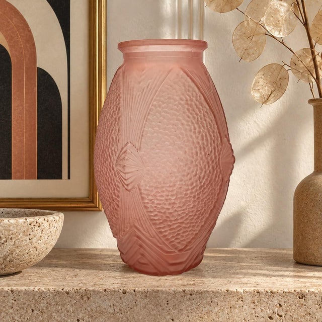 This pressed-molded, powder pink glass vase is a beautiful example of Art Deco aesthetics, with its strong geometric lines...