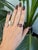 A 12.04-carat red star ruby cabochon sits at the centre of this solid 14K yellow gold ring, framed by twenty-six earth-...