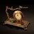 This is a charming vintage bronze table clock featuring an ornate, sculptural design inspired by traditional Asian motifs....