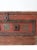This is an antique carpenter's chest. The painted wooden trunk features metal secured corners and bail handles on the...
