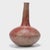 Covered in a beautifully worn red clay slip, this hand-formed African vessel has a dramatic silhouette of a squat, ovoid...