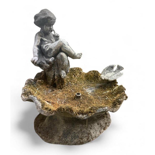 A charming and substantial vintage garden fountain hand-cast in solid lead. This piece features a seated cherub or putti...