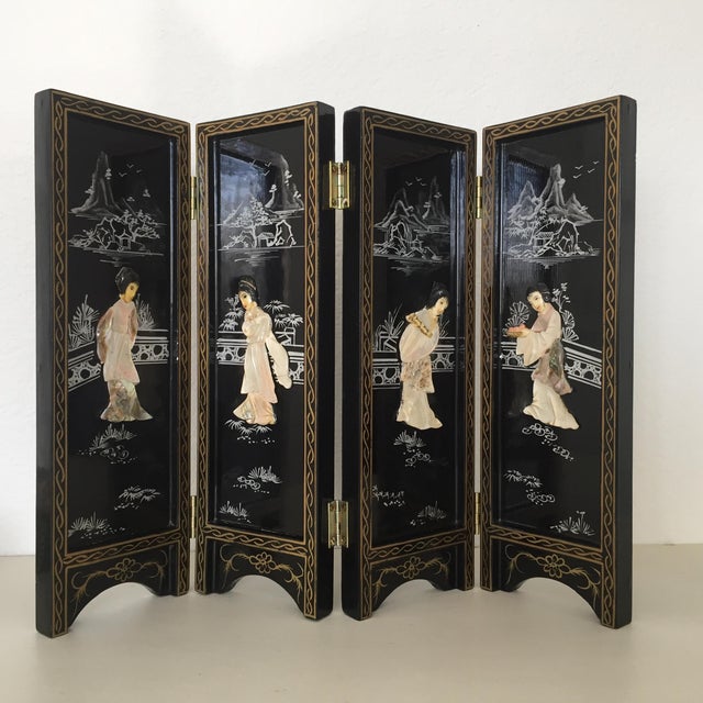 A vintage Chinese 4-panel mini folding screen featuring an elaborate black lacquered wood frame with brass hinges. The...