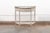 An elegant French painted wood demi-console, with marble top and brass accents, from the 19th century. This antique table...